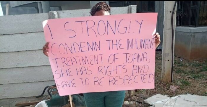 An activist holding up a placard that reads: I STRONGLY CONDEMN THE INHUMANE TREATMENT OF JOANA. SHE HAS RIGHTS AND HAVE TO BE RESPECTED.